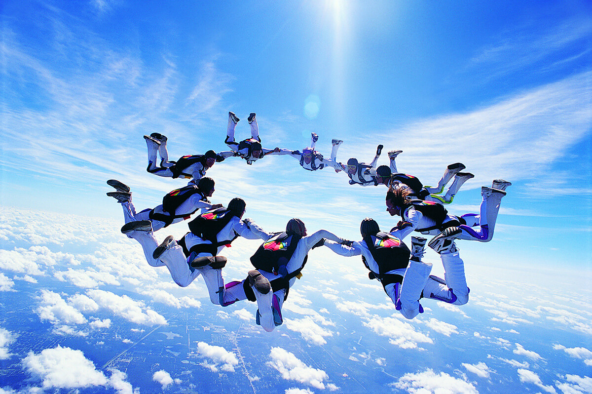 A group of skydivers in the sky holding hands